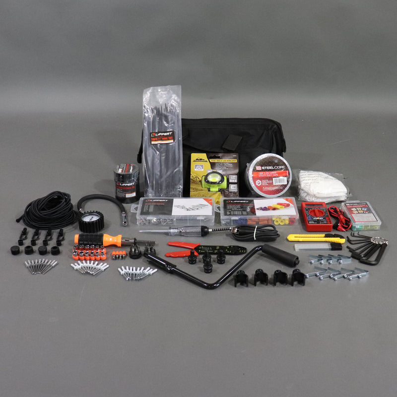 A variety of tools spread out on a gray surface, including a black tool bag, with many different items such as a crank handle, multiple pole caps, and various other tool components.