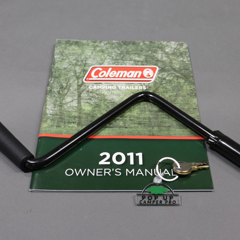 pop up camper pro logo keychain displayed with a owners manual and crank handle