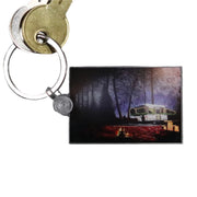 A clear acrylic keychain with a printed image of a camping scene titled 'Night Falls'.