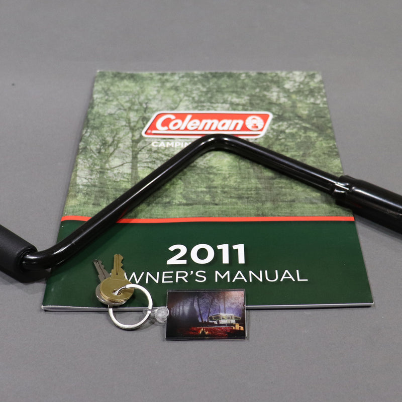 keychain displayed with an owners manual and crank handle