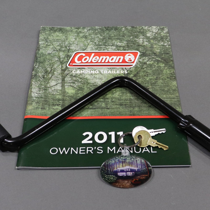 keychain displayed with an owners manual and crank handle