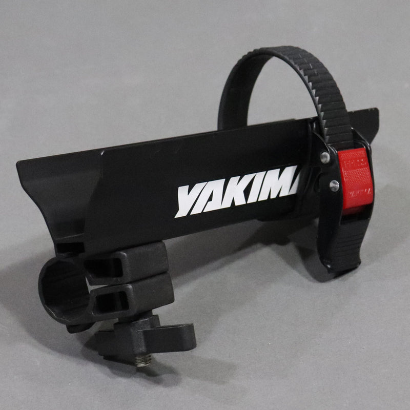 A Yakima crossbar attachment with a black body and red catch area, designed for roof mounted Yakima crossbar systems.