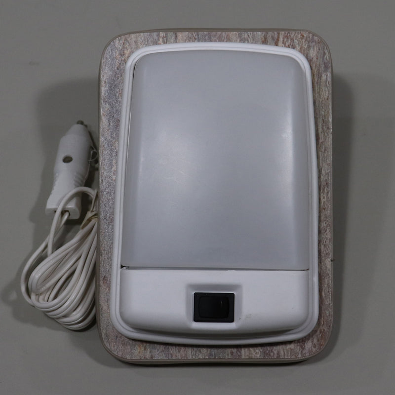 A 12 volt reading light with a cigar plug, light brown base and trim, connected to a white power cord.