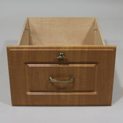 A beige wooden cabinet drawer with a frontal view showcasing the natural wood grain.