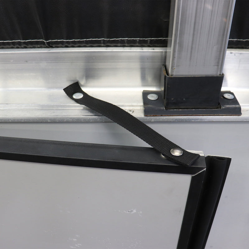 A black metal swing door check attached to a metal frame, with a rivet and screw studs as part of the installation.