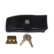 A black storage box latch with two keys inserted into a keyhole, against a white background.