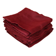 A stack of folded  burgundy fabric curtains on a plain white background.