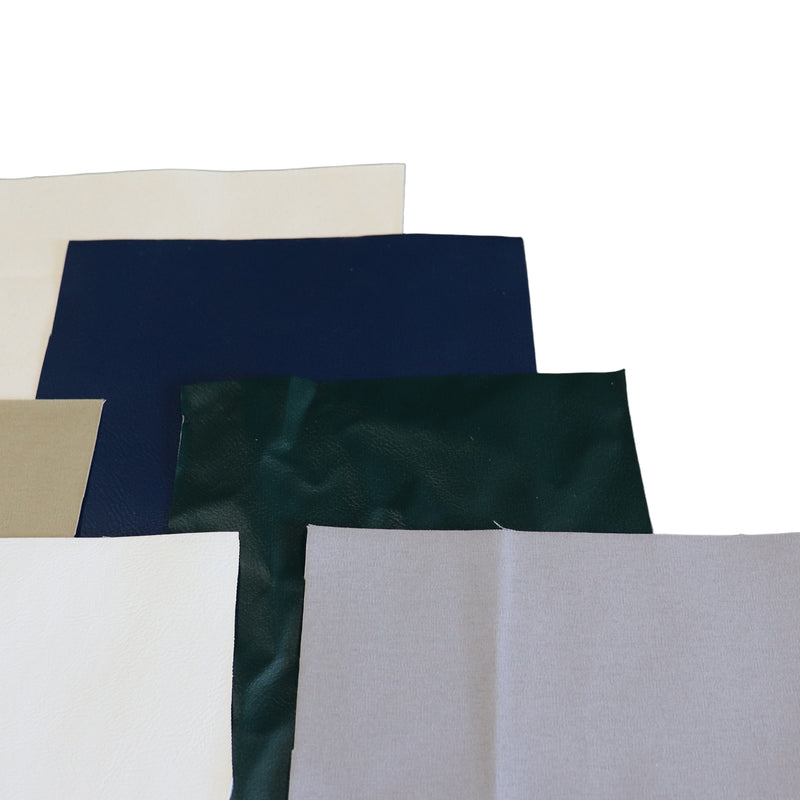 A stack of patch swatches in various colors, including cream, navy blue, dark green, beige, white, and light gray, arranged on a plain white background.