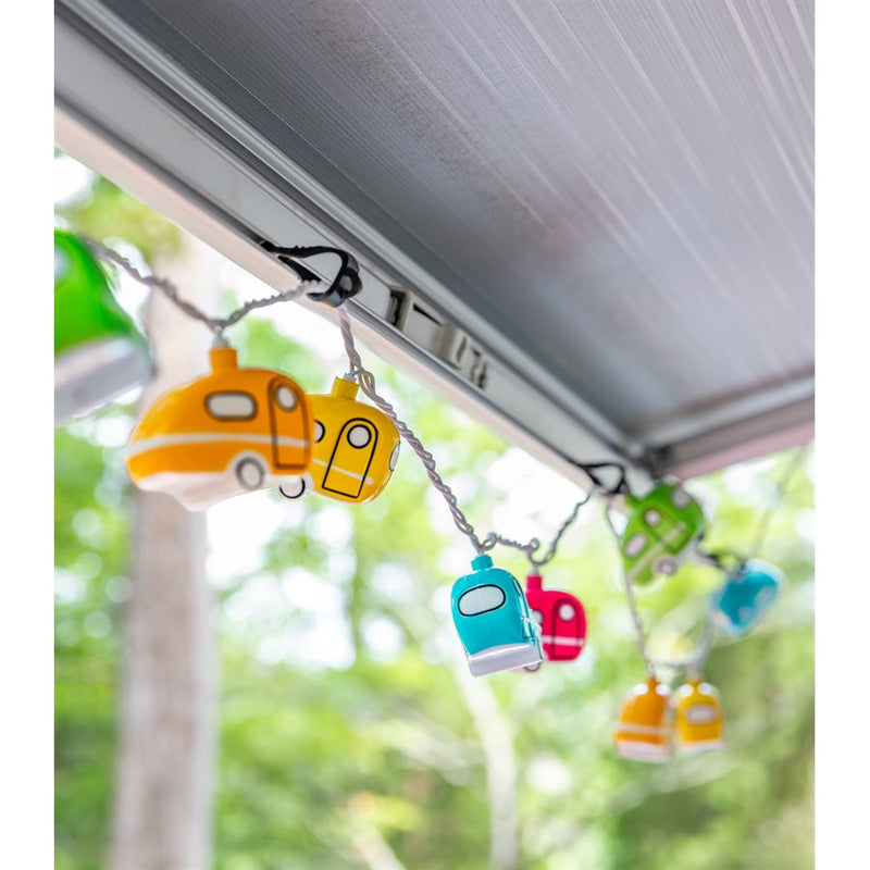 A series of LED party lights designed to look like retro travel trailers, hanging outdoors under a awning.