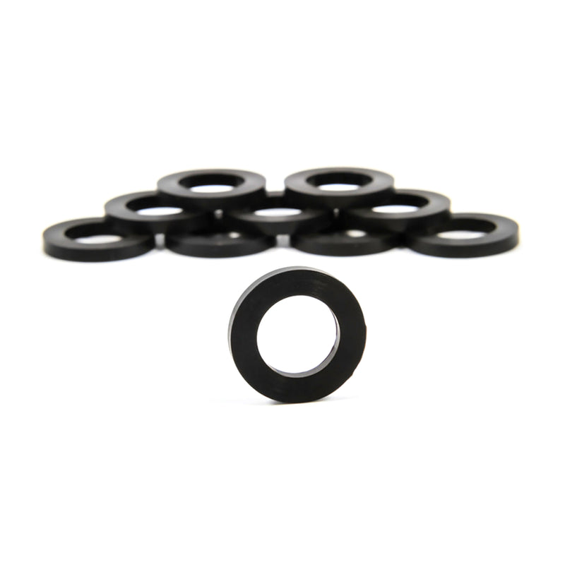 A collection of black rubber washers arranged in a loose stack with a clear background.