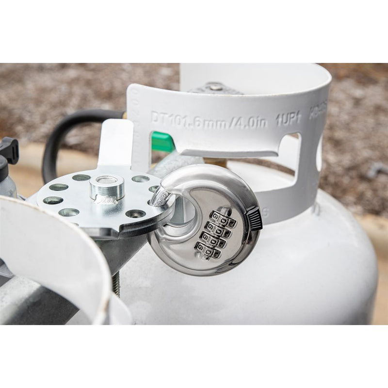 A propane tank lock with a combination lock mechanism is installed on a white propane tank.