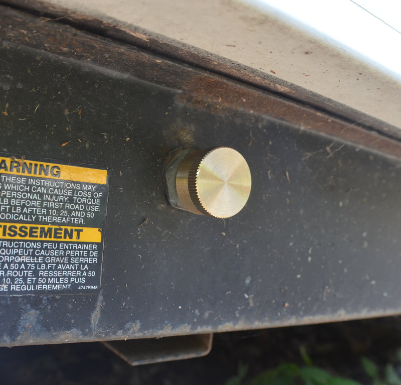 A brass cap for high pressure connections is installed on a LP (liquid propane) tank, visible against a natural background.