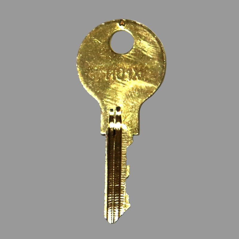 A gold-colored 1101x key for Coleman pop up campers