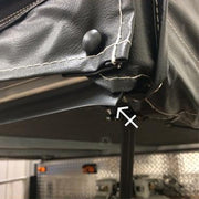 Close-up of a black bed seal installed on the corner of a recreational vehicle's bed, showing the seal's bead fitting into the bed track.