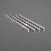 A set of four silver-colored aluminum channel braces laid out on a gray surface.