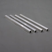 A set of four silver-colored aluminum channel braces laid out on a gray surface.