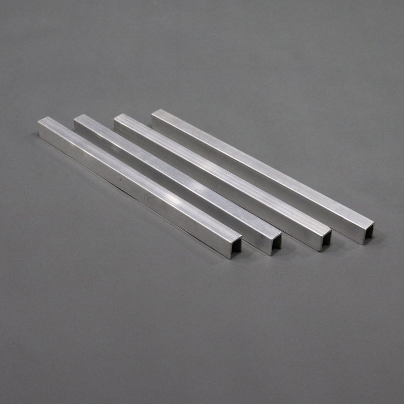 A set of four silver-colored aluminum channel braces laid out on a gray surface.