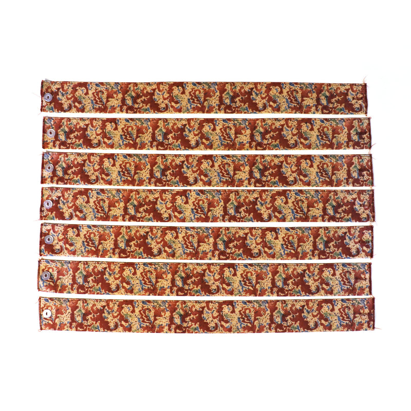A set of seven curtain tie backs with a floral pattern in red, brown, and multicolor.