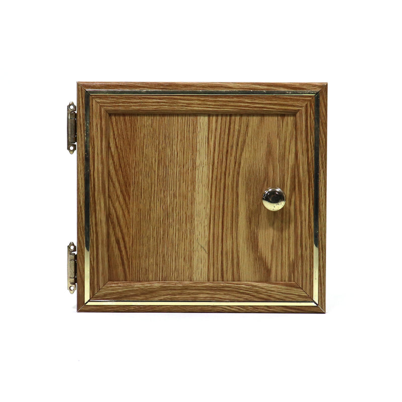 A wooden cabinet door with a gold colored molding, featuring a vertical grain pattern and a central knob.