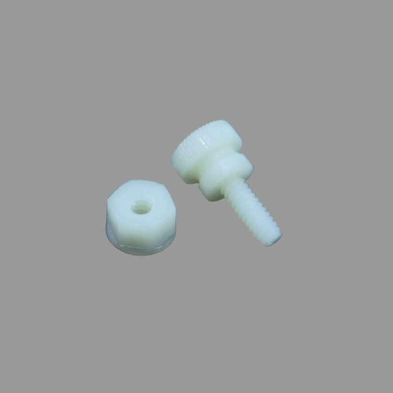 A white plastic screw and nut placed on a grey surface