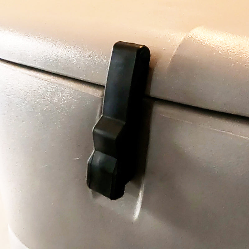 A black storage box latch installed on a grey surface, part of a camper storage compartment.